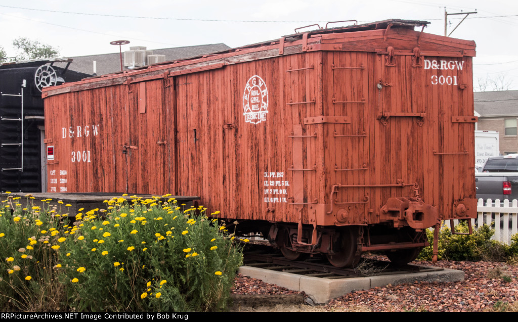 A narrow gage D&RGW wooden box car is on display near the Grand